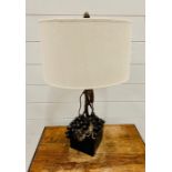 A Bronze Grape and vine themed lamp on a slate base with a white shade.