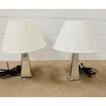 A pair of glass mirrored table lamps with cream shades