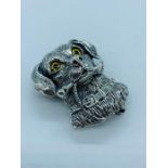 A silver brooch/pendant in the form of a Dog and his bone with glass eyes