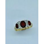 A 9ct gold ring set with three Ruby stones and four small diamonds (3.49g)