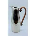 A chrome water jug with leather handle