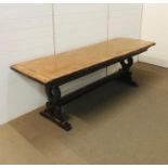 An oak planked top refectory table on shaped trestle supports (H74cm D70cm W230cm)