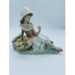 A Lladro figure of a girl sat with basket of flowers