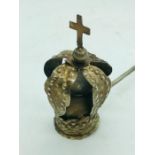 A white metal candle snuffer with interesting crown head