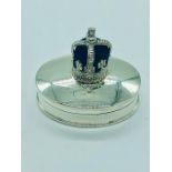 A silver pill box with crown shaped pincushion to the lid