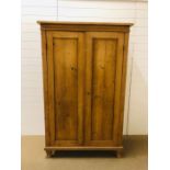 A small pine double wardrobe on square shaped feet (H178cm D48cm W112cm)