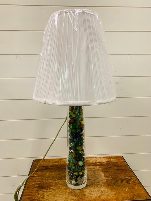 A glass table lamp filled with marbles