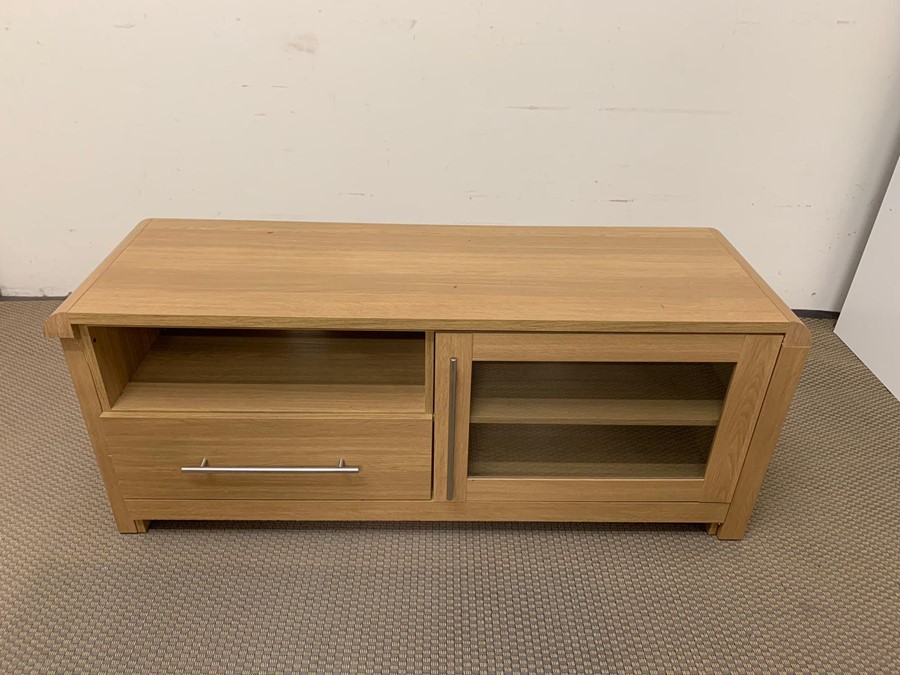 An entertainment unit with glazed door and storage drawers
