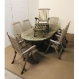 An oval extending teak garden table with six armchairs and a steamer chair with footrest by Royal