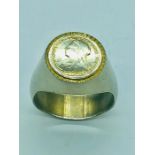 A Signet ring with a Victorian mounted coin, white metal.