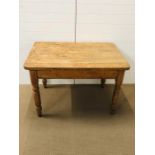 A pine kitchen table on turned legs with large drawer to one end (H73cm D81cm W114cm)