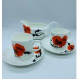 A pair of Susie Cooper Corn Poppy, Wedgwood cups and saucers, along with a sauce boat