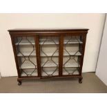 A glazed fronted bookcase by Wylie and Lochhead on ball and claw feet