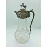 A cut glass claret jug with silver plated fitments and lion with shield finial.