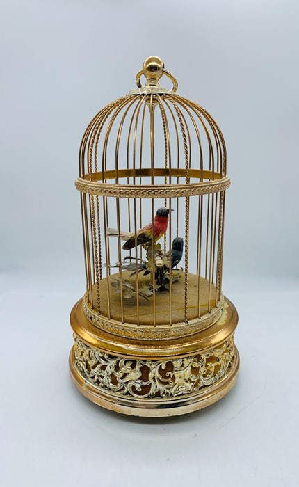 A Reuge music scribe Croix Automator of two song bird in a domed and gilded cage made in Switzerland