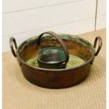 A heavy copper two handled cooking pot and small brass large handled pot