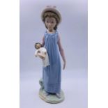 A Lladro figure of a child with a doll