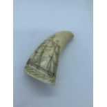 A whales tooth scrimshaw decorated with a sailing ship (H11cm W4.5cm)