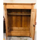 A large pine double wardrobe with inner shelf and hanging rail on bun feet (H193cm D63.5cm W154cm)