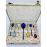 A boxed set of enamel on silver teaspoons and sugar spoon. One spoon AF
