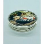 A silver pill box with enamel lid depicting a vintage race car