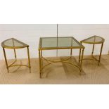 A square brass table with glass top with two matching half moon tables.