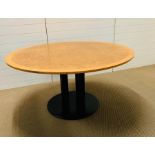 A large round walnut veneer table