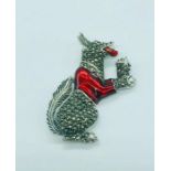A silver and enamel dog brooch with ruby eyes