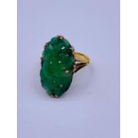 A Chinese jade ring on gold band with indistinct hallmarks