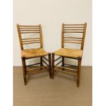 A pair of ladder back chairs with rush seats