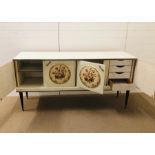 A fabulous kitsch sideboard with circular needle point panels to the doors on black and brass