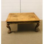 A carved Indian hardwood coffee table with iron corner plates on cabriole legs and claw feet