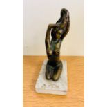 A small Bronze of a Nude, kneeling on a marble plinth.