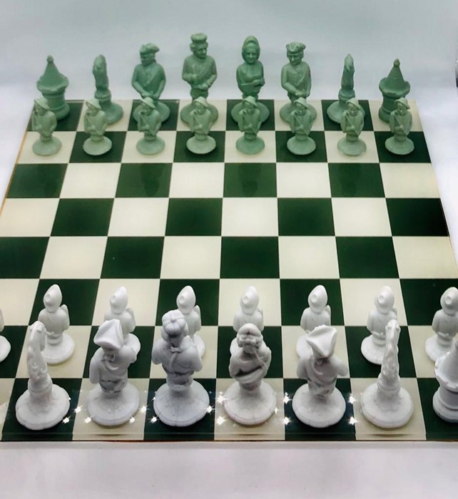 A German Furstenberg Biscuit Porcelain Chess Set in sage green and white in case with glass topped