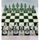 A German Furstenberg Biscuit Porcelain Chess Set in sage green and white in case with glass topped