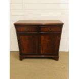 A small mahogany hallway cupboard with two drawers above