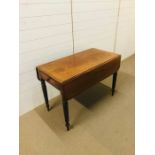 A drop leaf mahogany table with drawer to one end on turned legs