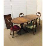 An extendable oval mahogany dining table with double splayed supports with brass paw feet and