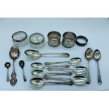 A selection of silver items to include spoons, napkin rings and two salts.