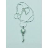 A silver and opal key pendant necklace on silver chain