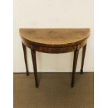 A yew demi-lune card table with string inlay detailing, a green felt top on tapered legs (W91cm