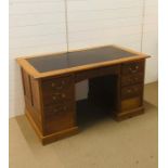 A double pedestal knee hole desk with central drawer and three drawers on one side and two on the