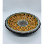 Studio pottery plate with a circular grid and dot pattern