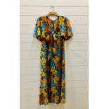 A 1970's Biba tea dress in a floral fabric predominantly orange and turquoise with original gold