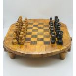 A wooden chess set on half turned legs with drawers either side to hold the pieces