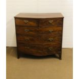 A flame mahogany two over three bow fronted chest of drawers on splayed feet with ornate brass
