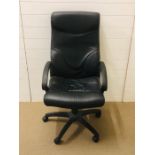 A large faux black leather style swivel office chair