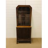 An oak display cabinet with glazed door