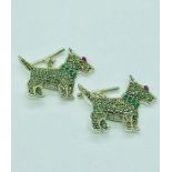 A pair of silver cufflinks in the form of dogs with emerald collar and ruby eyes.