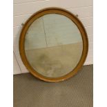 An oval foxed gilt mirror